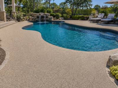 Backyard pool deck with a waterfall in rubber surfacing